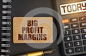 On the notebook there is a calculator with the inscription Today and a sign with the inscription - Big Profit Margins