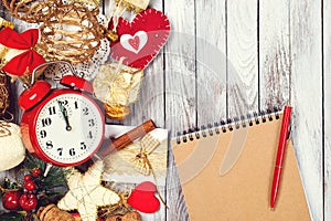 Notebook for to do list and goals about new year. Christmas composition with festive decoration and vintage alarm clock. Xmas. Noe