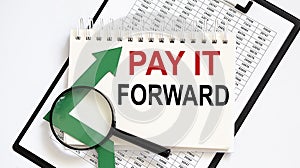 Notebook with Tools and Notes about PAY IT FORWARD with chart,business