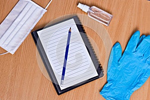 Notebook with vacuum tubes for blood collection and rubber gloves on a wooden table