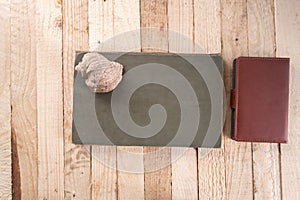 Notebook on a wooden background with seashells.