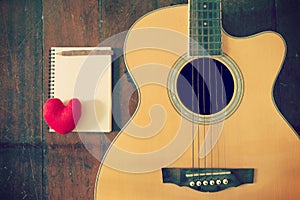 Notebook and wooden pencil with heart on guitar