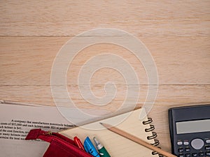 Notebook,wooden pencil,stationary,calculator and mathematics study worksheet on beige wooden background