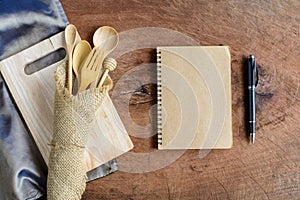 Notebook and wooden utensil in kitchen on old wooden background