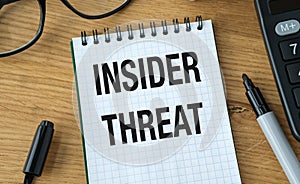 A notebook with the word Insider Threat written on it.
