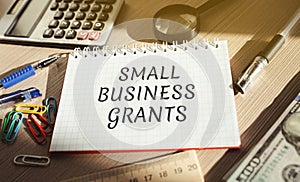 Notebook with words Small Business Grants. Free money for startups and existing businesses, including those impacted by the