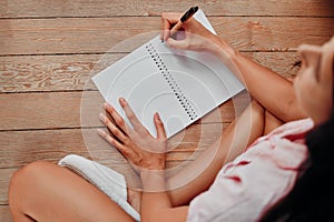 Notebook, writing and planning woman with journal for ideas, inspiration and creativity on wood floor above. Creative