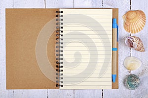 Notebook for writing your vacation memories. A blank sheet and seashells from the seaside