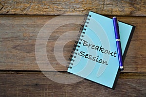 Notebook written with text BREAKOUT SESSION over wooden background