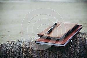 Notebooks,books and pen on the beach.