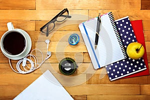 Notebooks, pen, glasses, apple on a wooden