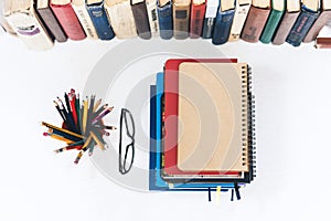 Notebooks piles, stack of books education back to school background, textbooks, glasses and pencils in holder with copy space for