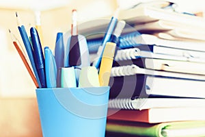 Notebooks piles, stack of books education back to school background, textbooks, glasses and pencils in plastic holder with copy