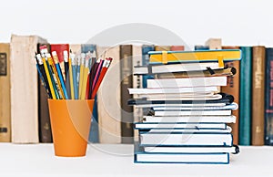 Notebooks piles, stack of books education back to school background, textbooks and pencils in plastic holder with copy space for