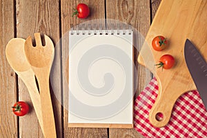 Notepad with blank space with cooking utensil on wooden table