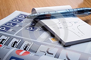 Notepad, book of traffic rules and pen on a desk table