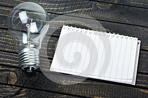 Notepad and bulb on table
