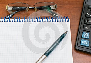 Notepad calculator pen glasses  on the table