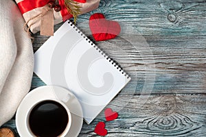 Notepad with coffee and a gift in a cozy, romantic atmosphere.