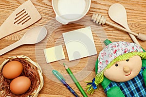 Notepad with cooking utensil on wooden table. Top view.