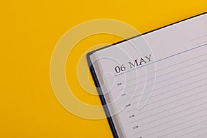 Notepad or diary with the exact date on a yellow background. Calendar for May 6 - spring time. Space for text
