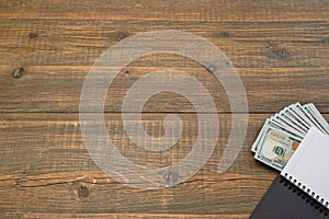 Notepad With Dollar Cash On The Brown Wood Background