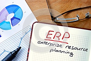 Notepad with Enterprise Resource Planning System (ERP) on office table.