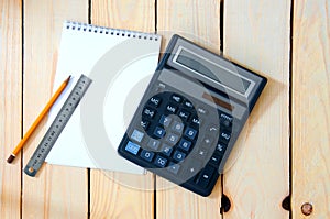 Notepad for entries with a calculator. pencil and ruler on a wooden table.