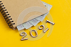 Notepad with Euro banknotes and 2021 made of wooden parts