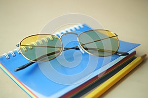 notepad, eyeglass and a pencil on wooden table photo