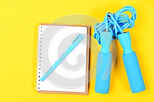 Notepad and fitness tools. Block note, pen with sports equipment