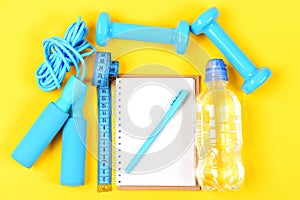 Notepad and fitness tools. Notebook, pen and gym equipment