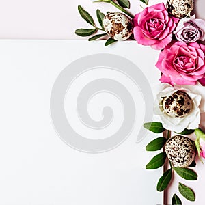 Notepad and floral composition in pastel colors. Happy easter card. Roses, leaves and quail eggs close-up
