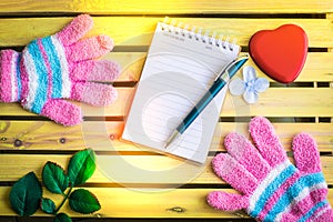 Notepad with glove on wood board background.using wallpaper for education, business photo.Take note of the product for book with p