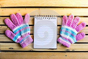 Notepad with glove on wood board background.using wallpaper for education, business photo.Take note of the product for book with p