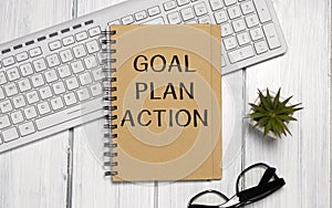 Notepad with Goal plan action text on keyboard with pencils
