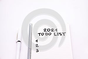 Notepad inscripted 2021 to do list with a pen on a white background close up