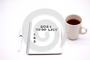 Notepad inscripted 2021 to do list with a pen on a white background close up photo