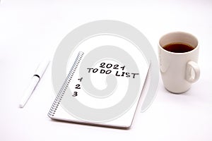 Notepad inscripted 2021 to do list with a pen on a white background close up