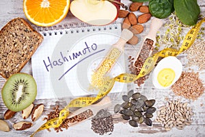 Notepad with inscription hashimoto and best ingredients or products for healthy thyroid. Food containing vitamins