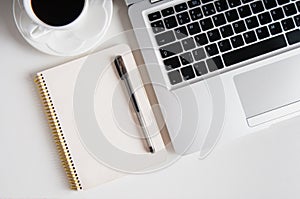 Notepad, laptop and coffee cup on wood table