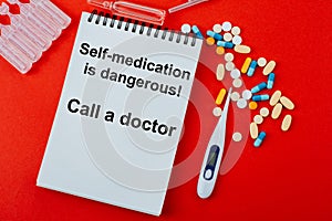 Notepad ,a medicines, a thermometer and ampoules on a red background