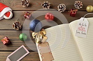 Notepad for new year greetings and decorations on a brown wooden background.