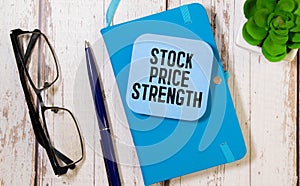 notepad with note paper with the inscription - STOCK PRICE STRENGTH