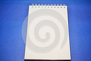 notepad for notes on a sheet of blue paper isolated