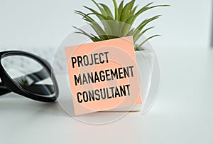 Notepad on office desk with text: Project Management consultant