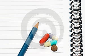 Notepad, one pencil, pills