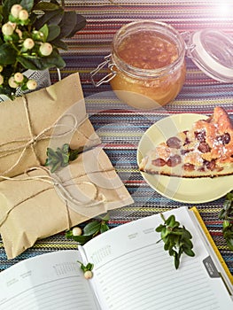 Notepad, paper envelope and piece of pie on the colorful tablecloth