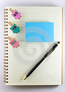 Notepad, paperclip and pen on white background