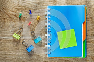 Notepad pen drawing pins paper clips on wooden board